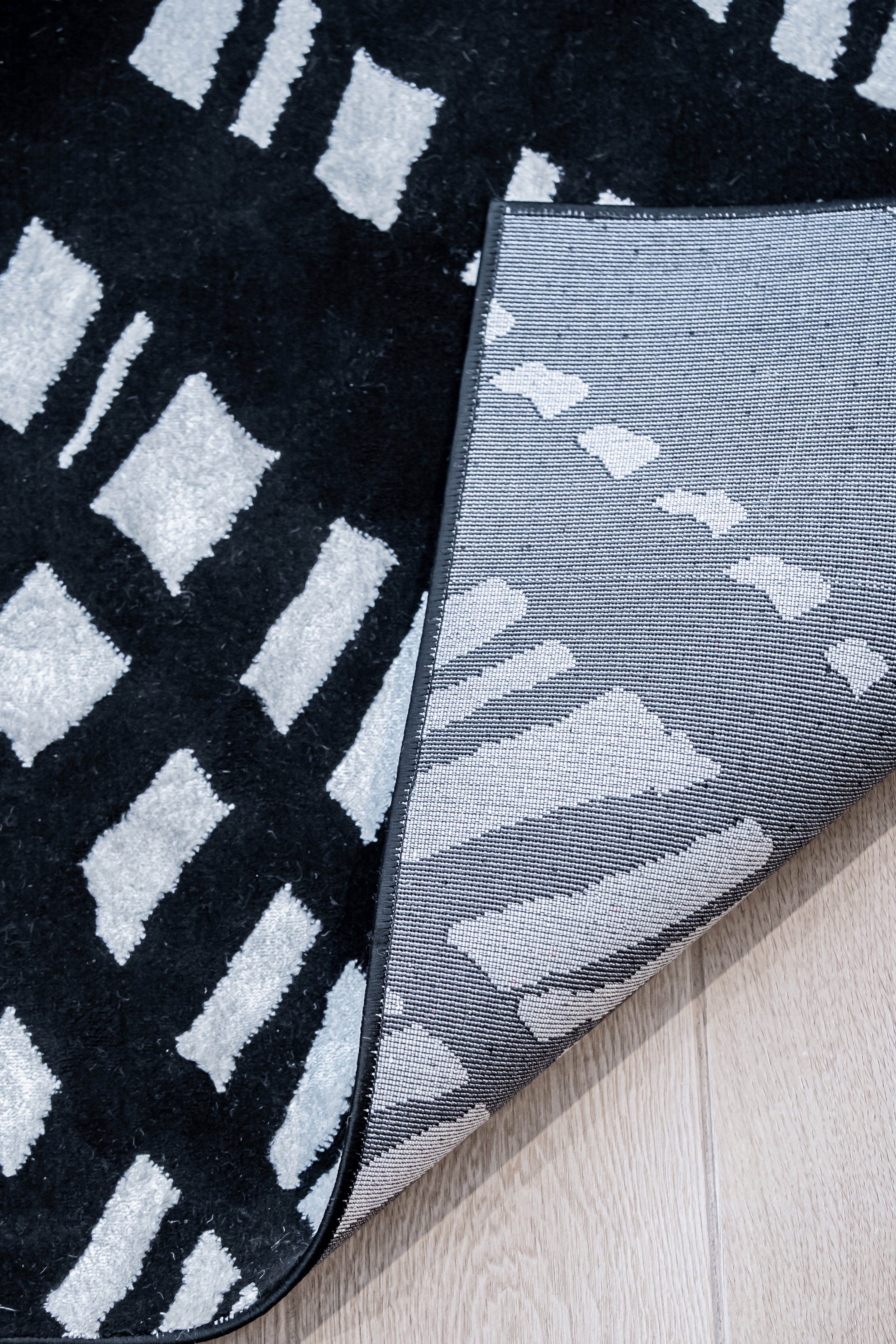 De nuestra colección POLAR: Este tapete color negro con blanco, elaborado con&nbsp;hilo de poliéster brillante de alta calidad, aporta suavidad, estilo y un sutil brillo que realza cualquier espacio. Su diseño contemporáneo y textura confortable lo convierten en una pieza funcional y decorativa para el hogar.

Características:

Tejido a máquina.
Hilo de poliéster brillante de alta calidad.
Textura suave al tacto.
Reverso de algodón para mayor resistencia y durabilidad.
Diseño plegable para fácil almacenamie